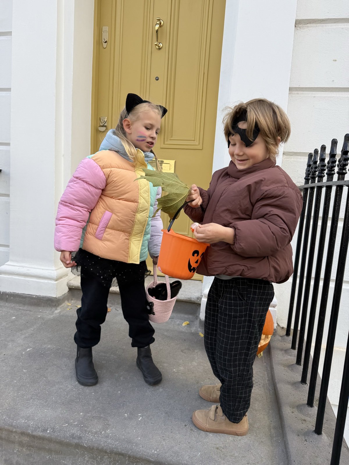 Elvin and Anita trick-or-treating with a pumpkin bucket